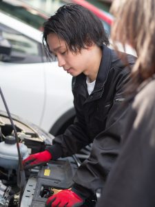 福岡の中古車販売店NEXUM代表の冨永が整備結果説明をしている様子